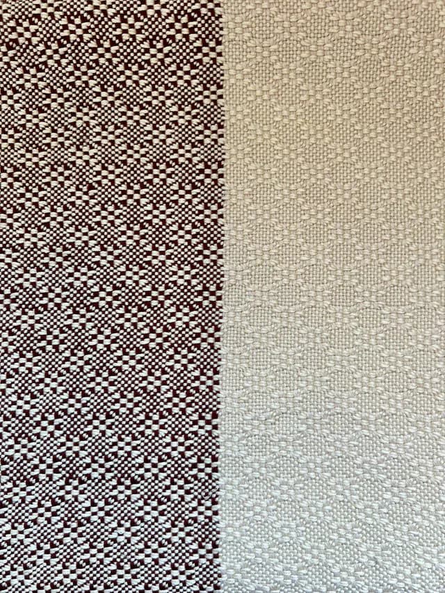 Détail rapproché du tissage géométrique bordeaux et écru de l'écharpe.